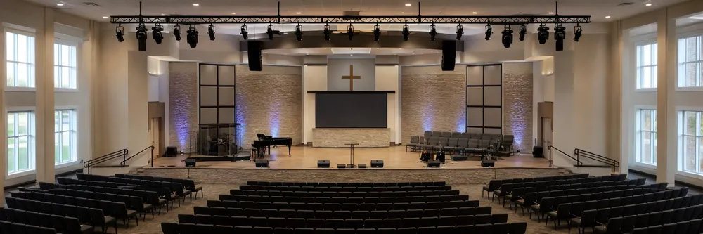Large church sanctuary outfitted with professional stage lighting array — representing volume lighting projects for worship spaces