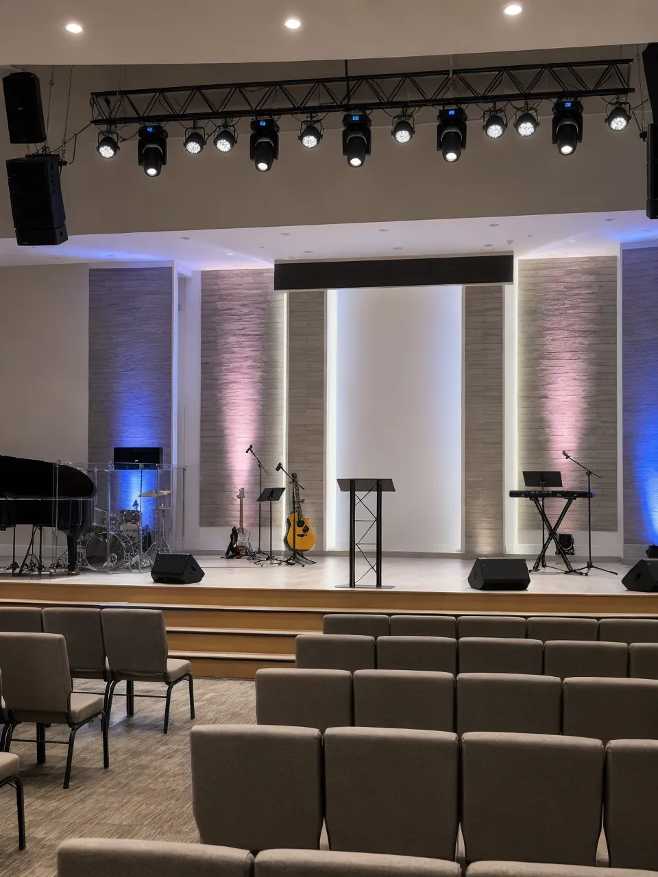 Church stage lighting fixtures illuminating a modern worship sanctuary with warm front wash and color accents