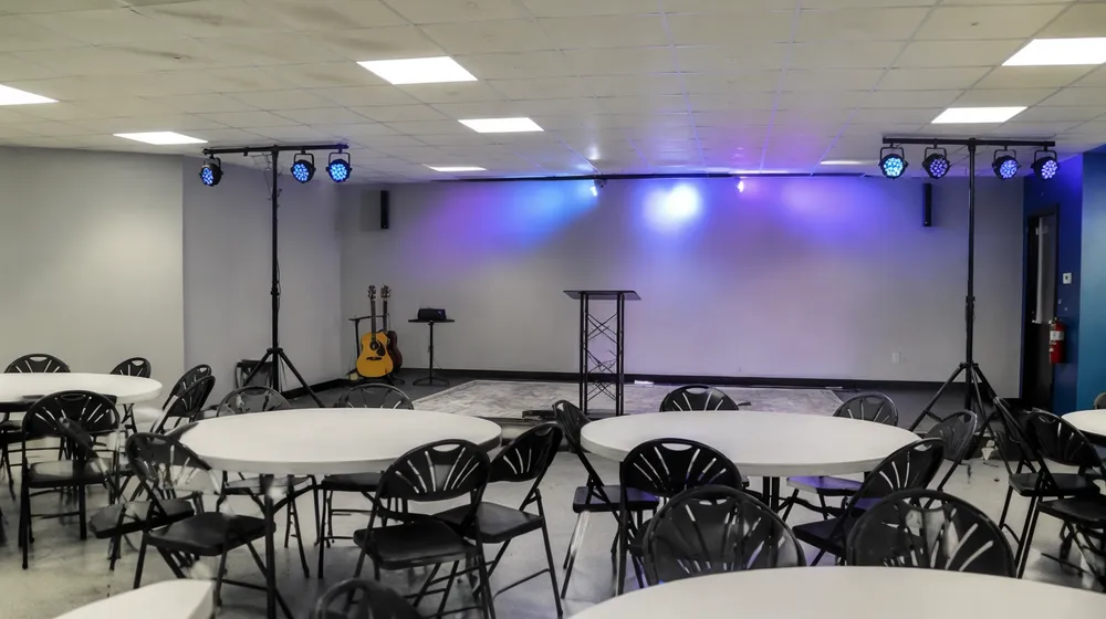 Multi-purpose fellowship hall with LED par fixtures on T-bar stands and low ceiling