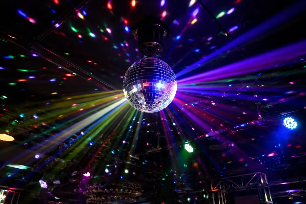 GDMonkey disco ball light fixture projecting multi-color beams across a dark venue ceiling