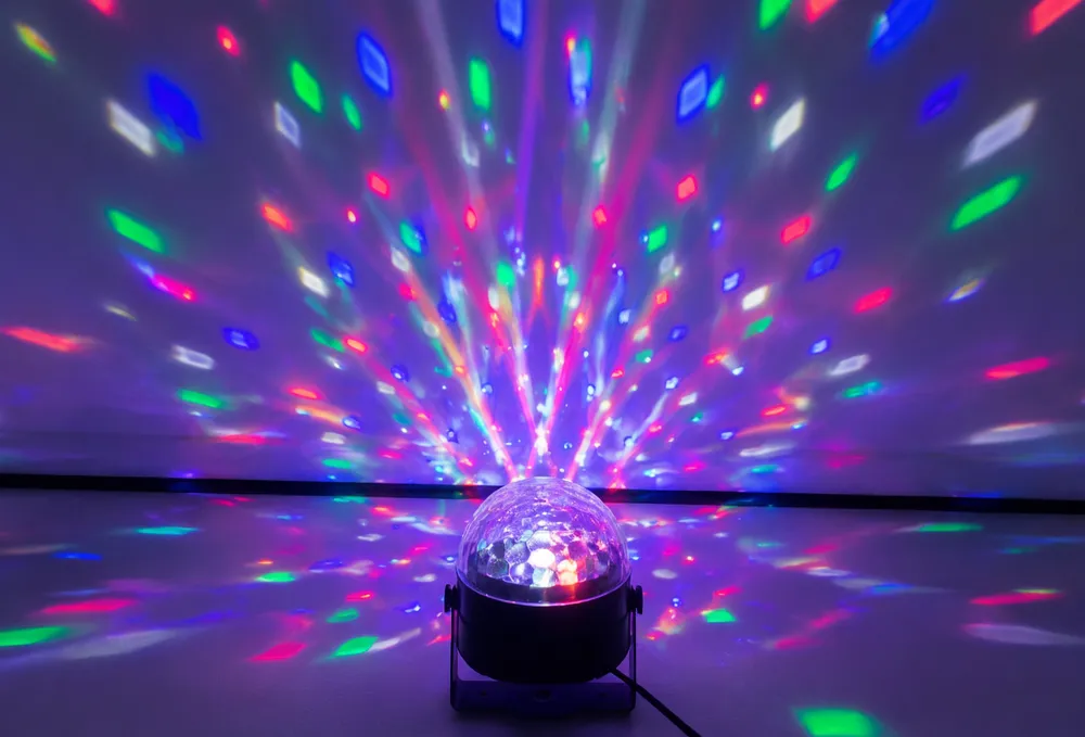 LED disco DJ lights multi-color effect fixture with rotating beams projected on walls
