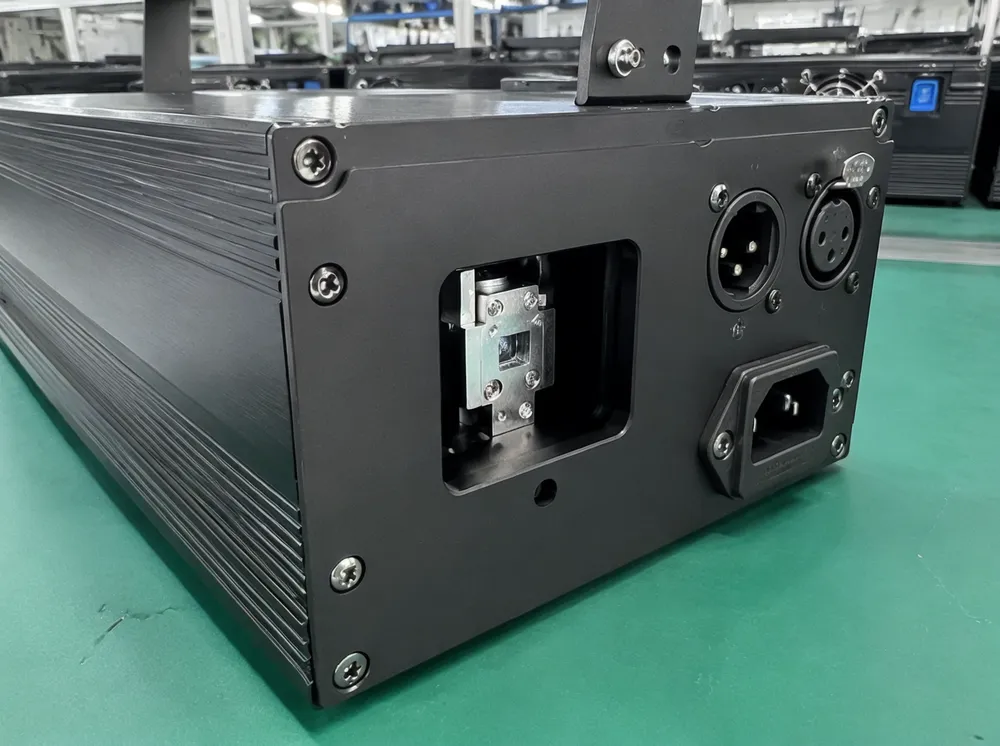 Close-up of disco DJ laser light unit showing aluminum housing, diode aperture, and DMX connectors