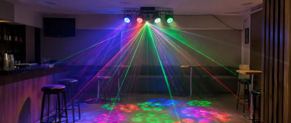 LED laser DJ hybrid fixture installed in a small bar venue showing dual LED wash and laser beam effects