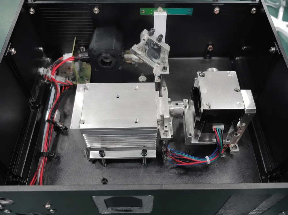Interior view showing aluminum heatsink plate and stepper motor scan system inside a mini DJ laser unit
