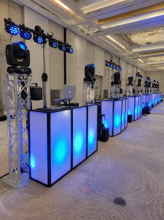 Multiple identical DJ booth lighting setups deployed at parallel event rental positions