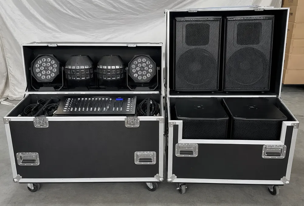 Complete DJ lights and speakers setup package with LED PARs, derby effects, powered speakers, and DMX controller arranged in two road cases