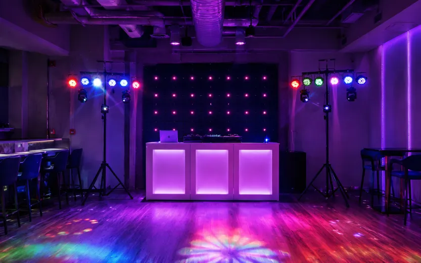 Compact bar venue with gigbar systems flanking DJ booth and dance floor