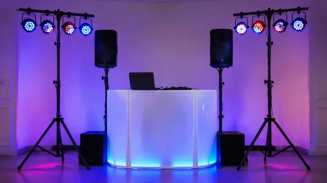 Mobile DJ lighting setup with paired T bar stands supporting PAR lights at event