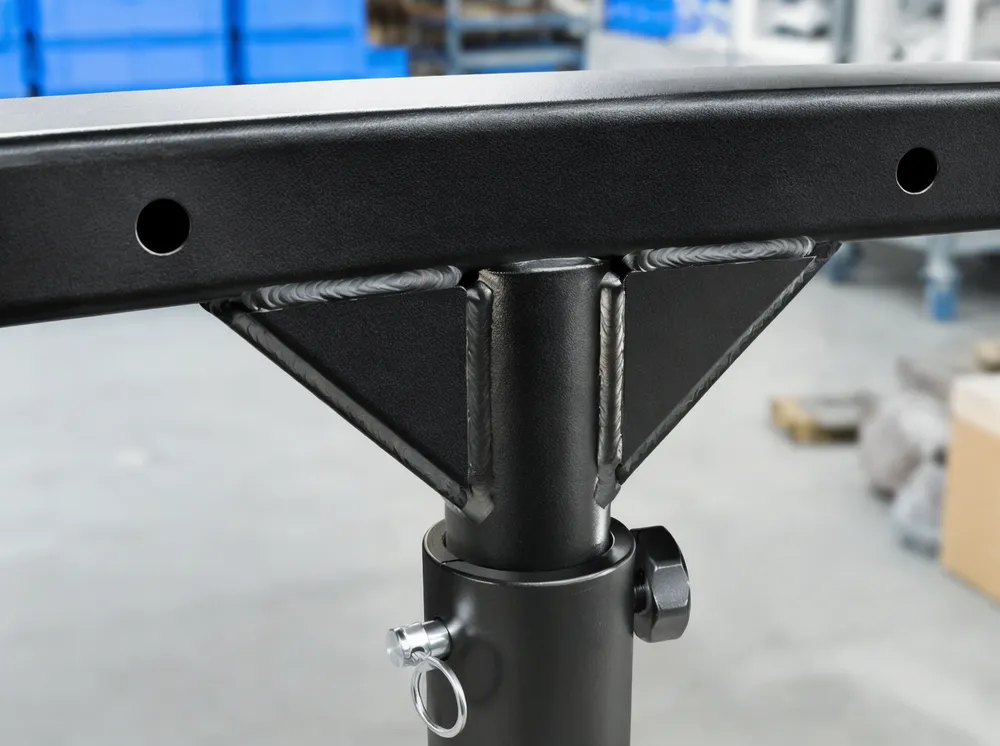 Close-up of TIG-welded gusset plate reinforcement at T bar junction showing dual-side weld lines