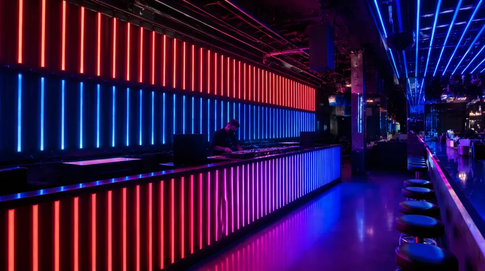LED tube lights installed behind DJ booth and along bar counter in nightclub