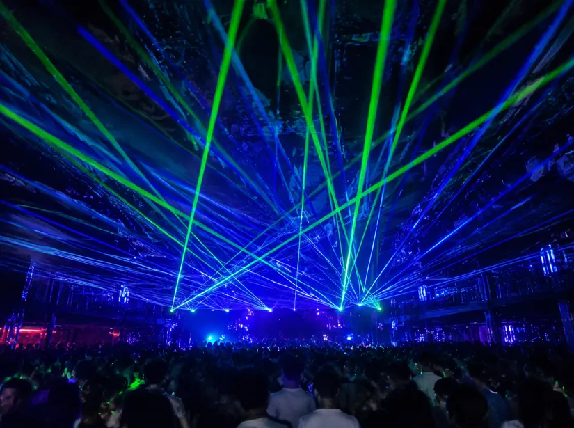 Laser aerial beams cutting through haze in a nightclub installation