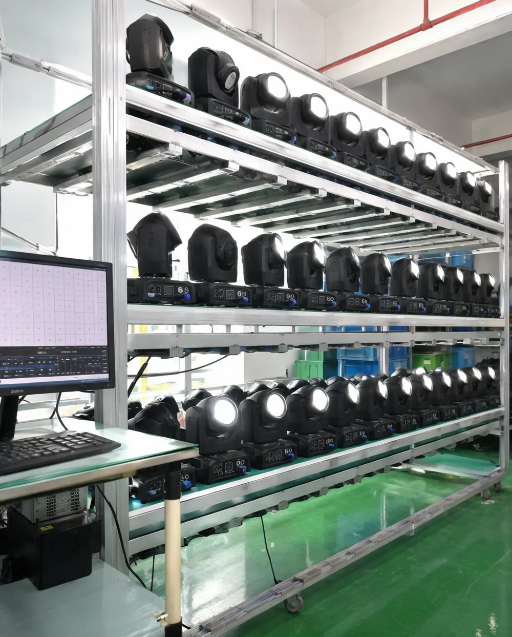 Mini moving head fixtures undergoing 48-hour aging test on burn-in rack with DMX monitoring