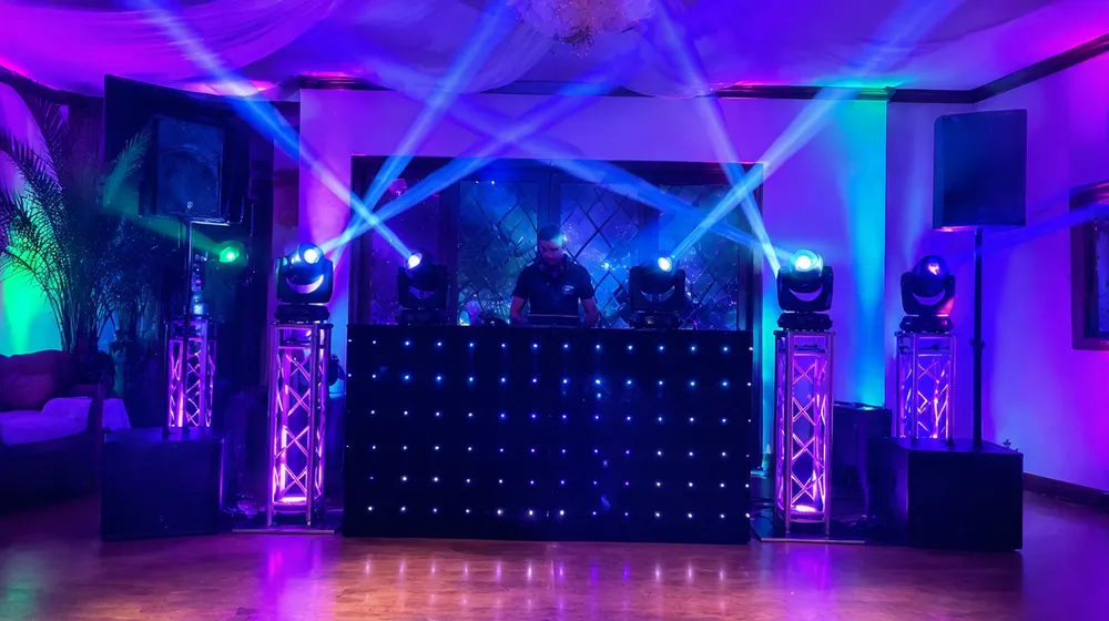 Mobile DJ setup with mini moving head lights in a club environment