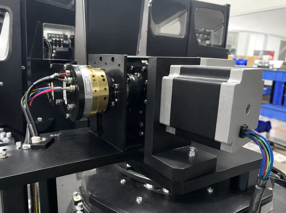 Spider fixture bar rotation mechanism showing slip-ring power transfer system and oversized stepper motor