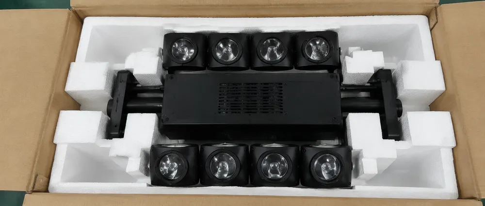 Spider moving head fixture secured inside molded foam cradle packaging showing lateral bracing at bar pivot points