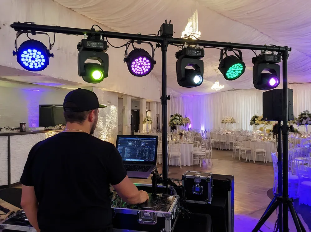 Mobile DJ setting up DMX party DJ lights for a wedding reception with 6-fixture rig