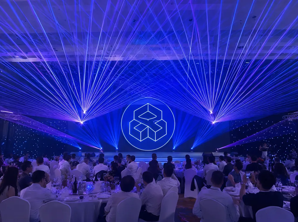 Laser projectors creating branded stage backdrop at corporate event