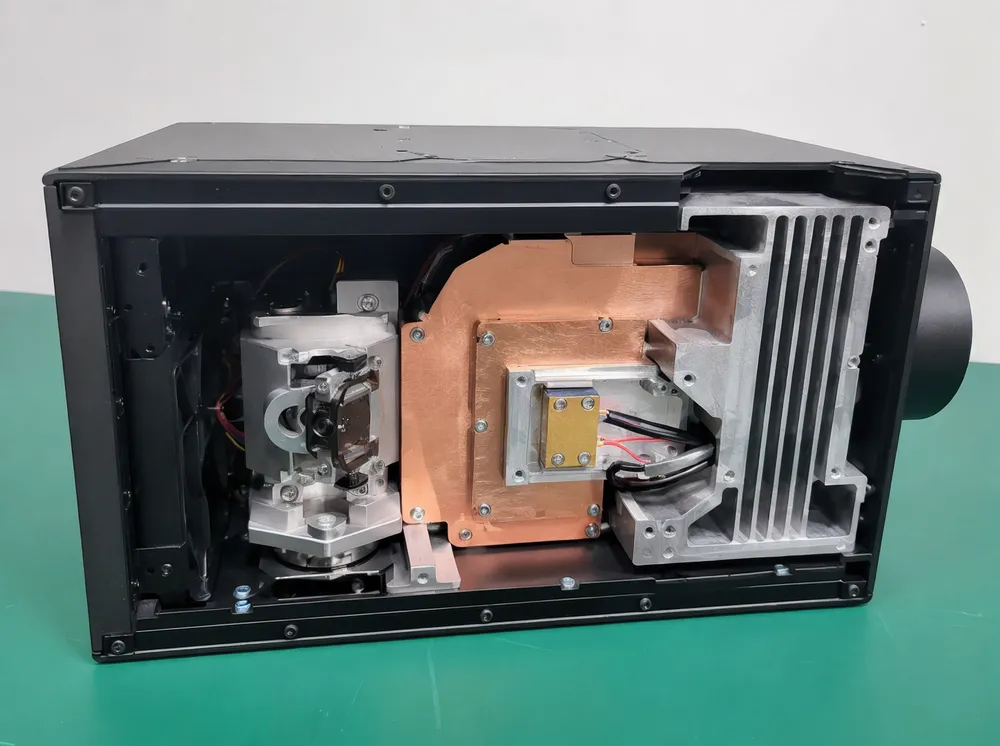 Cutaway view showing galvo scanner, copper heat spreader, and die-cast aluminum thermal path in GDMonkey laser projector
