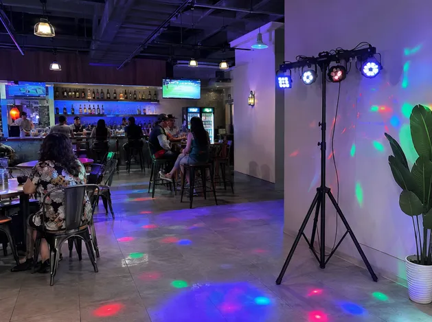 Tripod lighting system in a bar setting providing ambient sound-active lighting effects