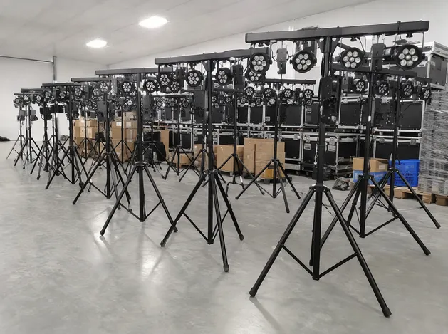 Event rental company warehouse with rows of tripod lighting systems ready for deployment