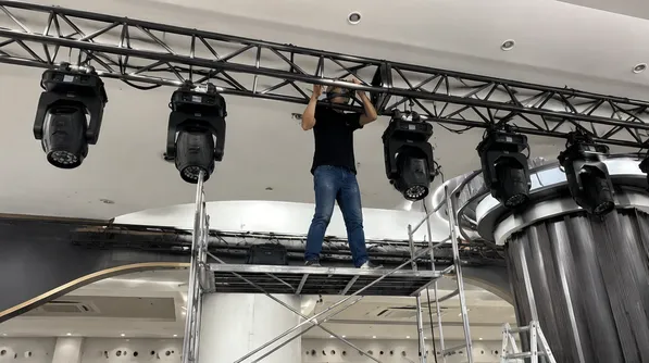 AV integrator installing professional DJ lights in venue construction