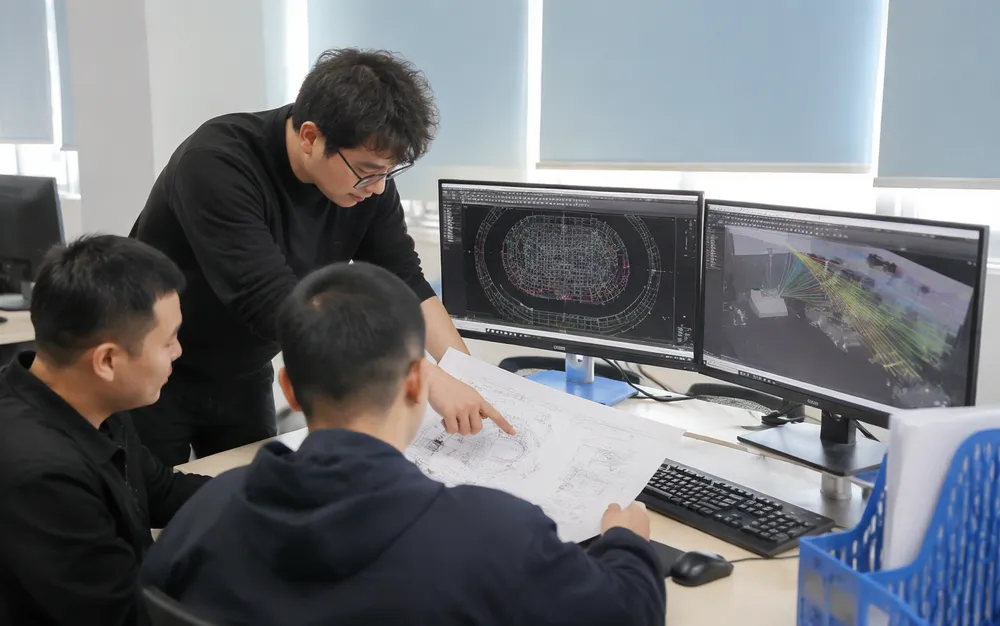 Stage lighting design engineering team reviewing optical layout plans with venue dimensions