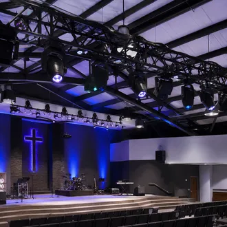 Moving head spot and wash fixtures installed on permanent church truss