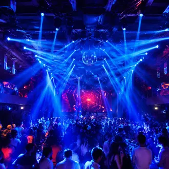 Beam moving heads cutting through haze in a nightclub venue
