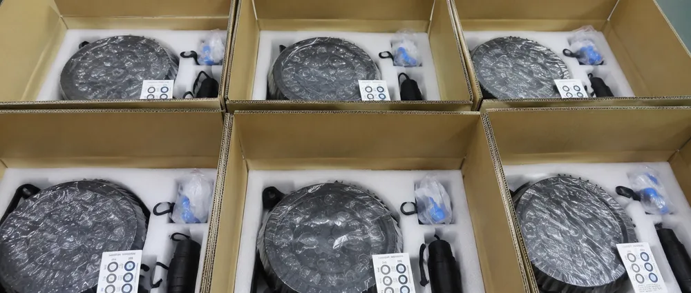 Outdoor stage lighting fixtures packed in custom EPE foam inserts inside double-wall corrugated cartons with silicone connector caps and humidity indicator cards visible