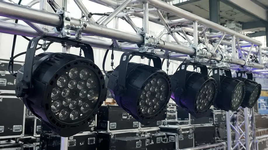 Par light fixtures rigged on touring truss system for live event production showing die-cast aluminum housings with integrated Omega brackets
