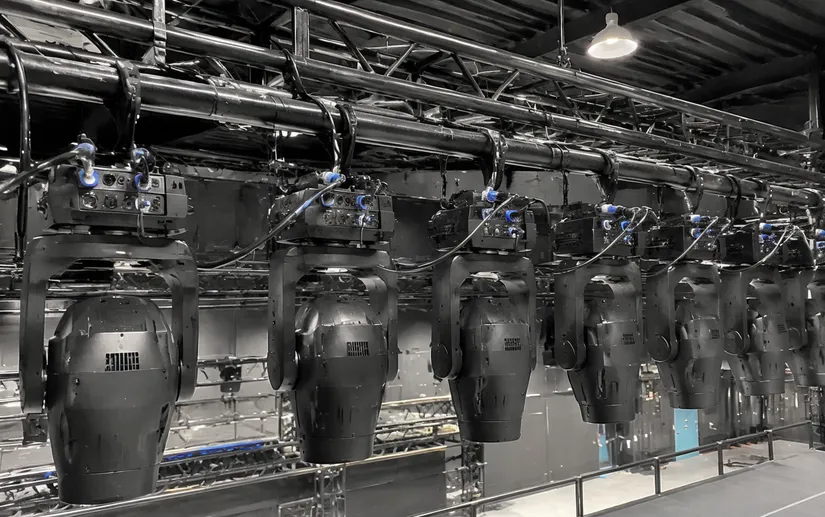 DMX spotlights installed in a multi-fixture theatre rig with daisy-chained control