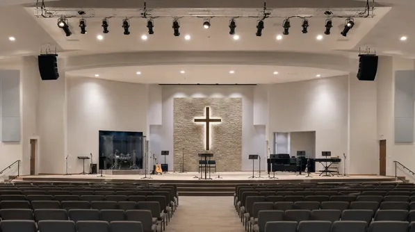 Modern sanctuary with warm white stage spotlights on worship platform