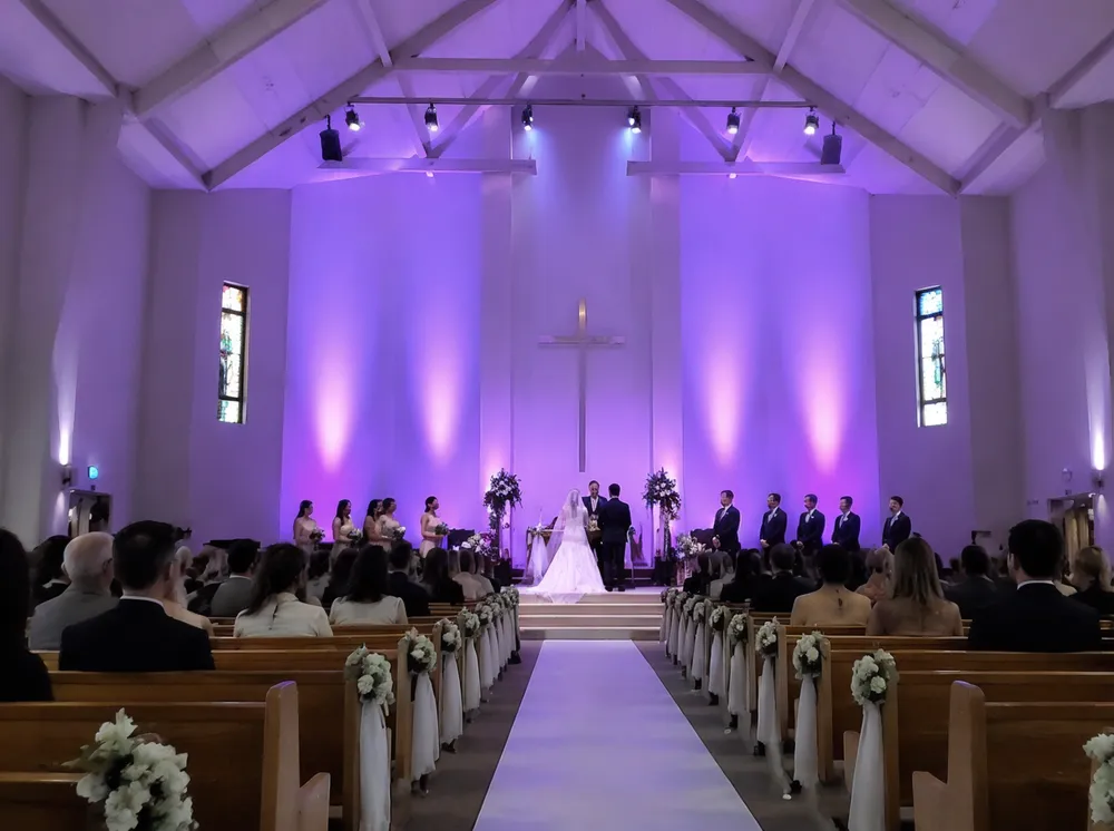 LED wash fixtures illuminating a high-ceiling church sanctuary for a wedding ceremony
